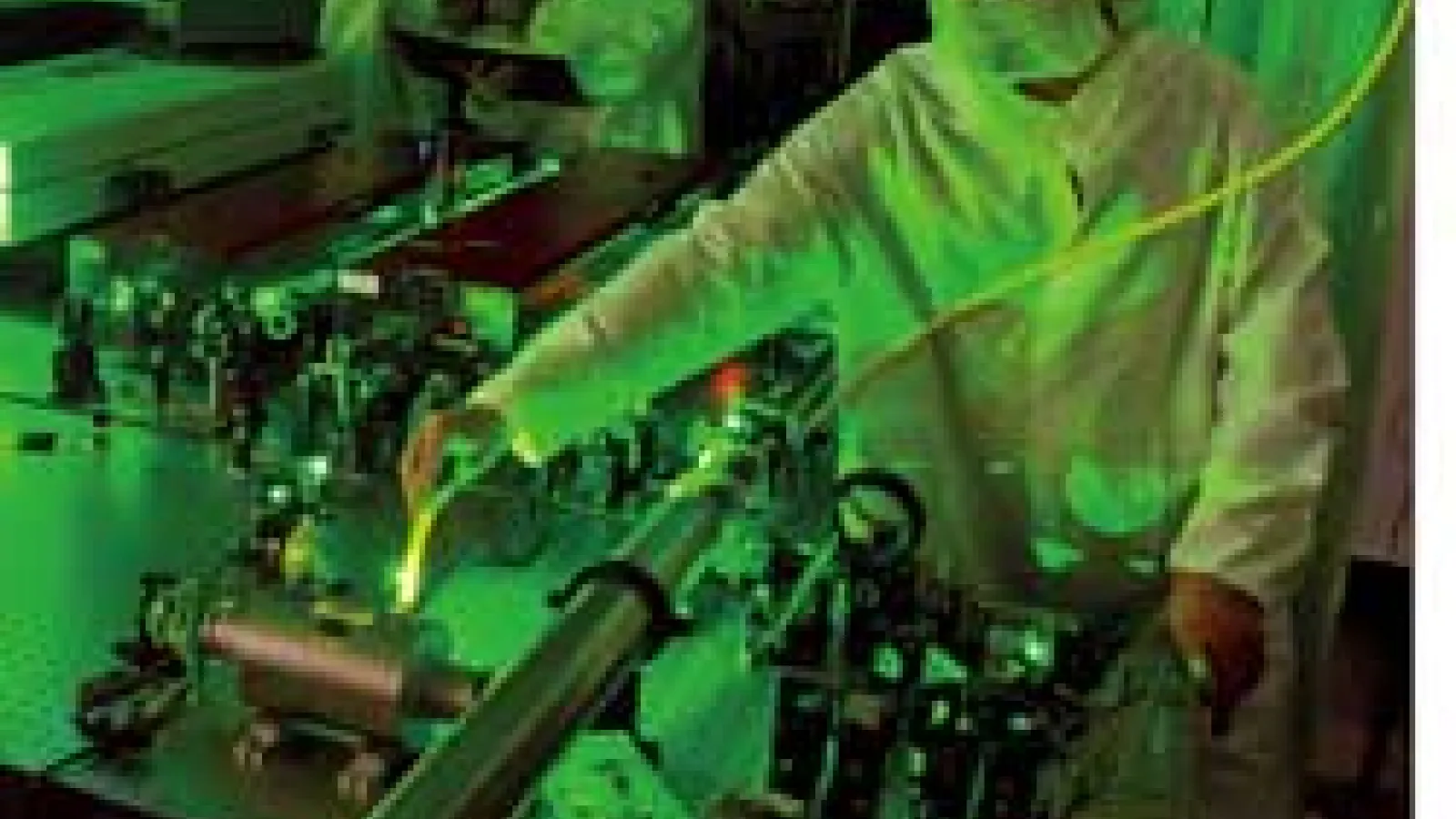 Scientists working with scarlet laser, illuminated by green laser scatter